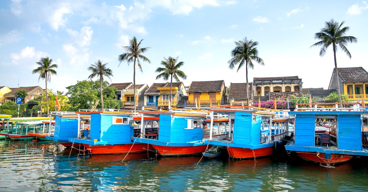 Cruising to Vietnam - Boats moored on river embankment near old town of Hoi An Cruising to Vietnam - Boats moored on river embankment near old town of Hoi An
