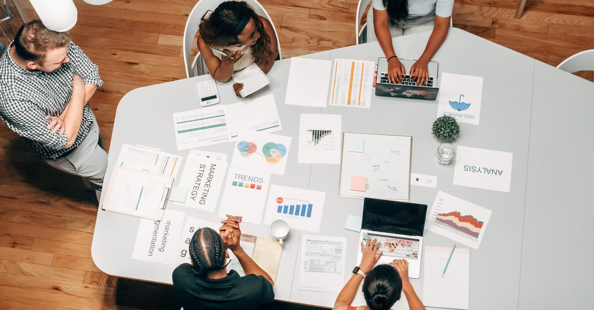 Customs Duty on Bringing 2 Laptops from US to India - People in the Office Discussing a Project Customs Duty on Bringing 2 Laptops from US to India - People in the Office Discussing a Project