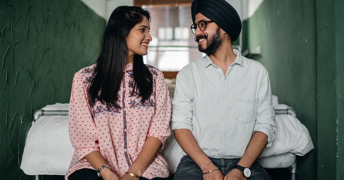 Date of arrival on an Indian e-visa - Happy couple sitting near bed and looking at each other Date of arrival on an Indian e-visa - Happy couple sitting near bed and looking at each other