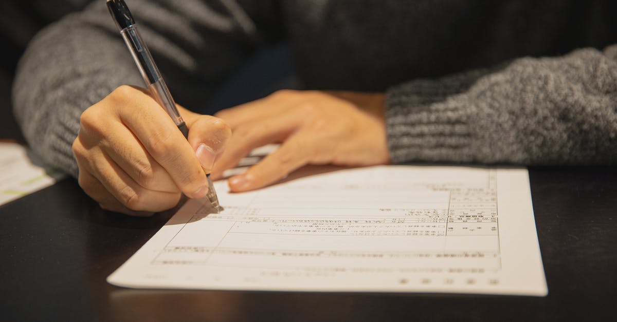 Dealing with bully/rogue consular official - Man filling in form on parer at table Dealing with bully/rogue consular official - Man filling in form on parer at table