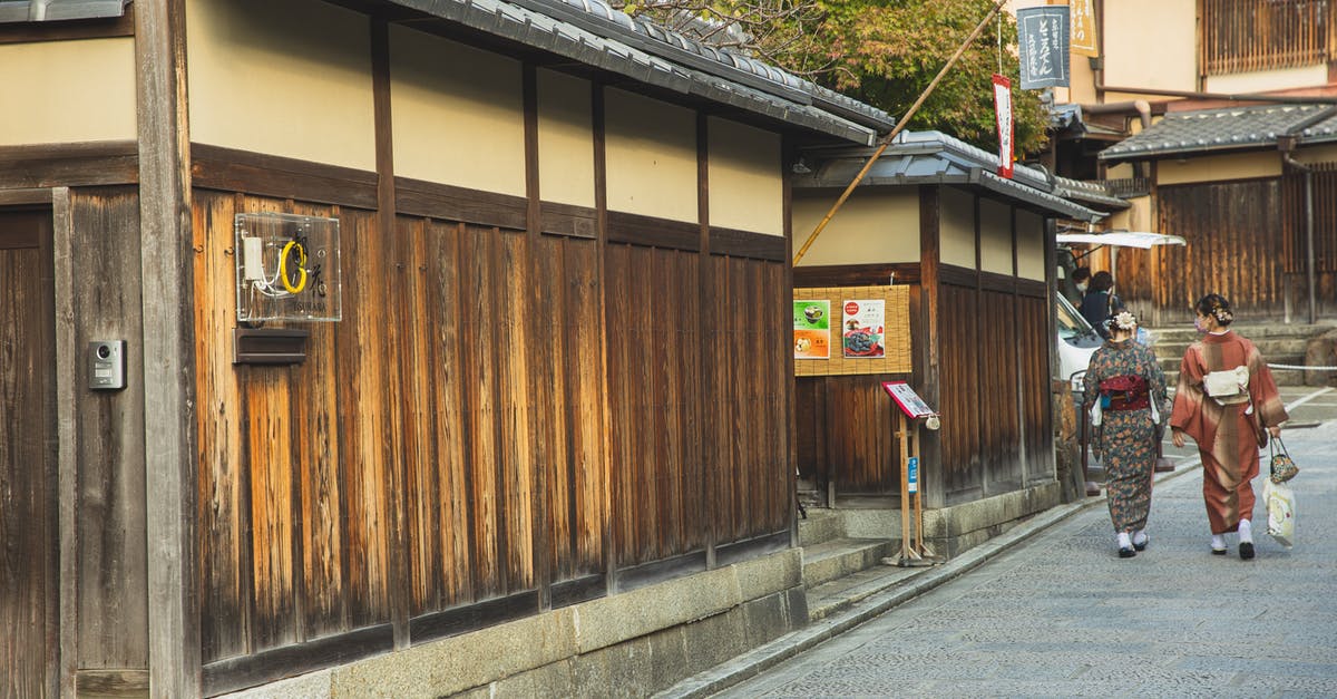 Delhi, Beijing or Japan for sightseeing in May with a teenage daughter? [closed] - Back view of unrecognizable local Japanese ladies in traditional kimonos walking on paved street near typical aged wooden houses in Kyoto