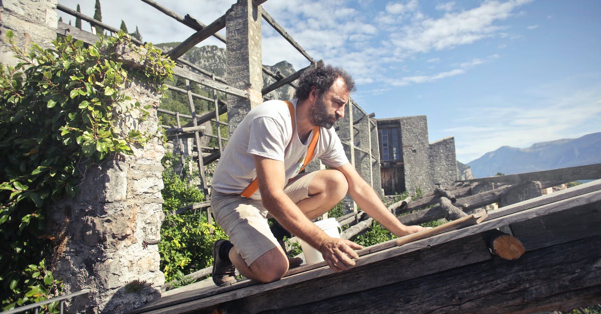 Denial of Entry or Travel Ban in Schengen area - Focused man building roof of wooden construction Denial of Entry or Travel Ban in Schengen area - Focused man building roof of wooden construction