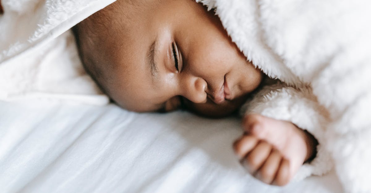 Dependent Australian child Deported from Bali to Malaysia as transit [closed] - Sleeping newborn black baby lying on bed