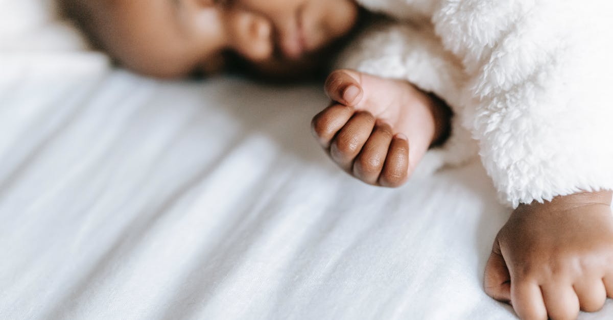 Dependent Australian child Deported from Bali to Malaysia as transit [closed] - Adorable ethnic infant sleeping on bed