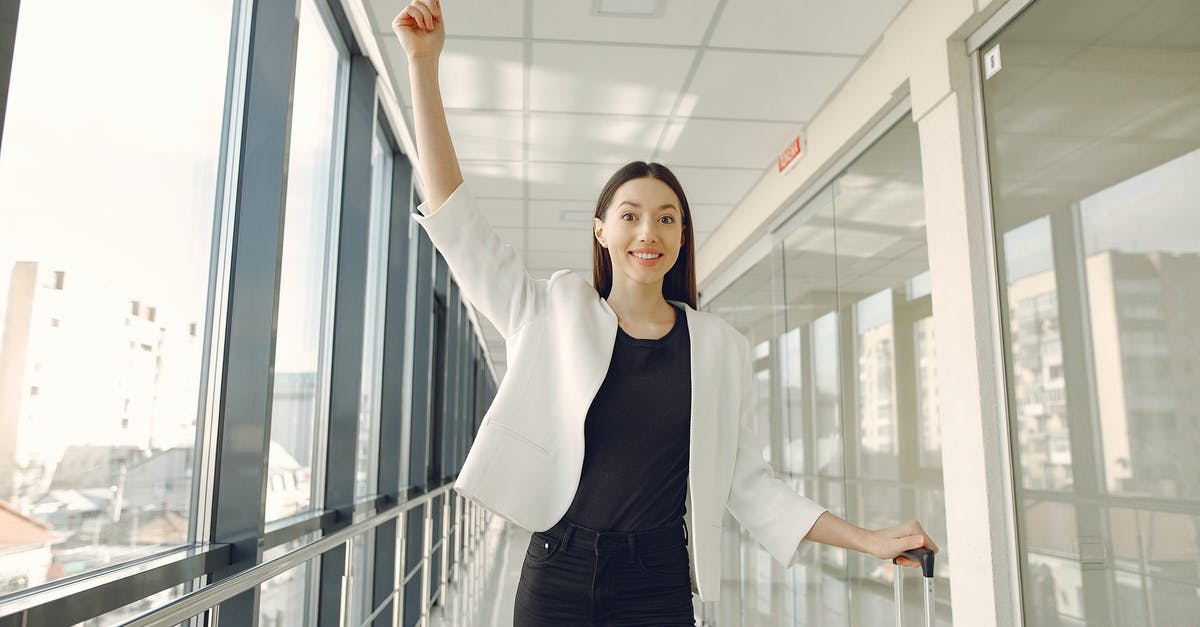 Difference between after departure cancellation and no show - Smiling woman showing passport in modern corridor Difference between after departure cancellation and no show - Smiling woman showing passport in modern corridor