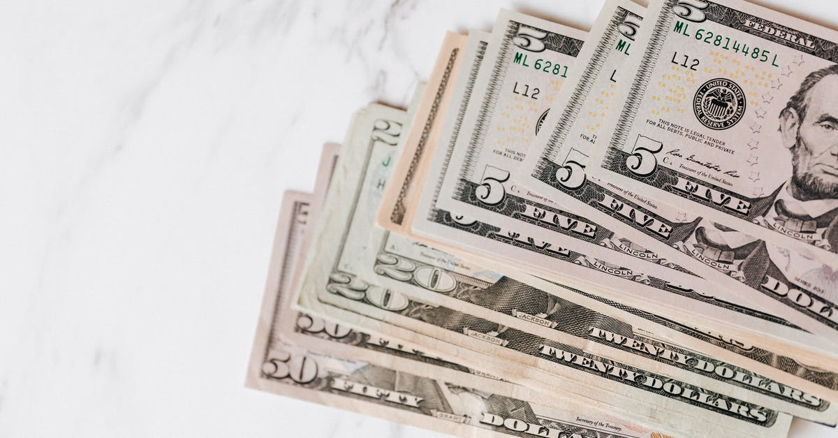 Difference of changing USD currency for going to US versus somewhere else - Different dollar bills on marble surface