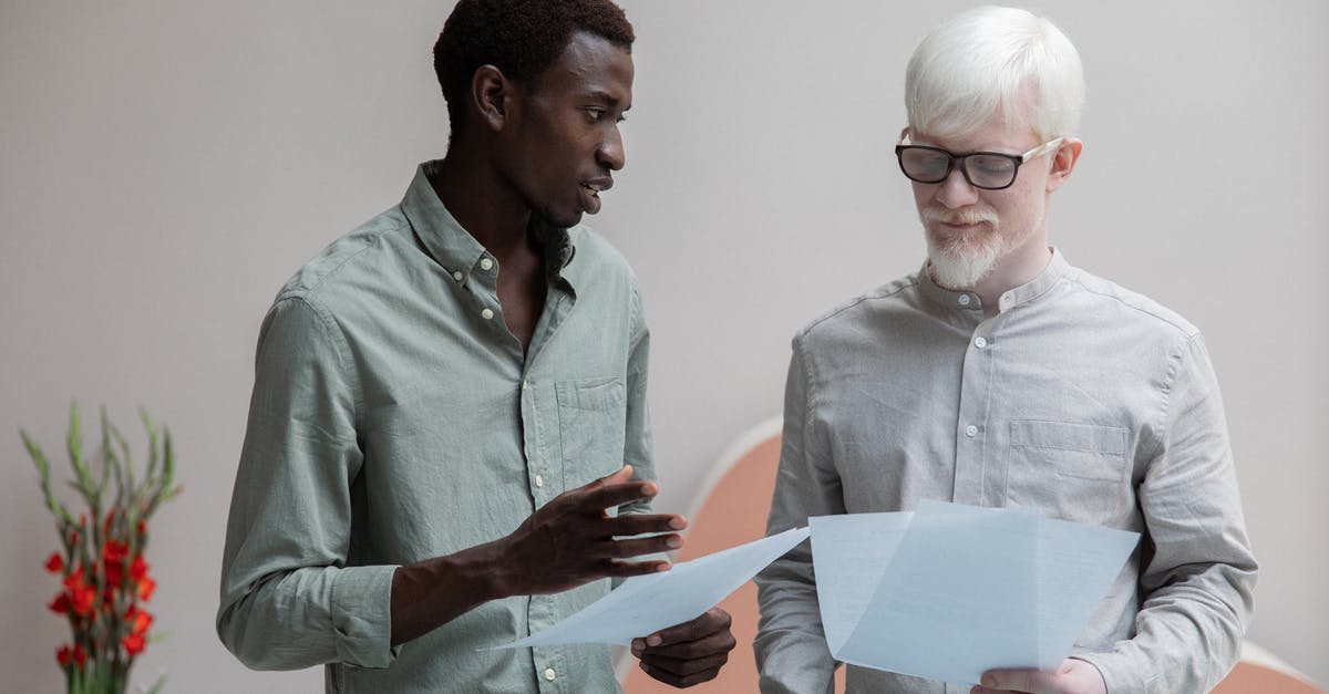 Different documents shown when entering and exiting the UK - could this lead to immigration assuming I've overstayed? - Concentrated African American man and albino coworker in eyeglasses working with papers while discussing work in contemporary office with flower
