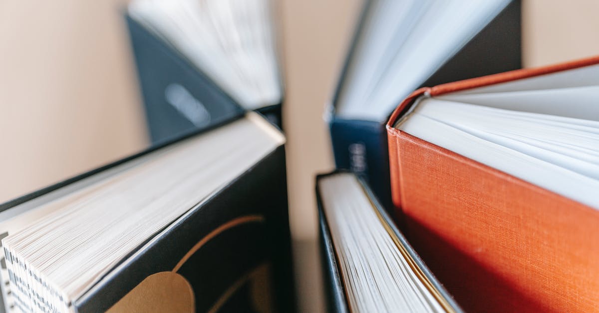 Different surname in university ID and passport - From above of various books with hardcovers placed on wooden table in daylight Different surname in university ID and passport - From above of various books with hardcovers placed on wooden table in daylight