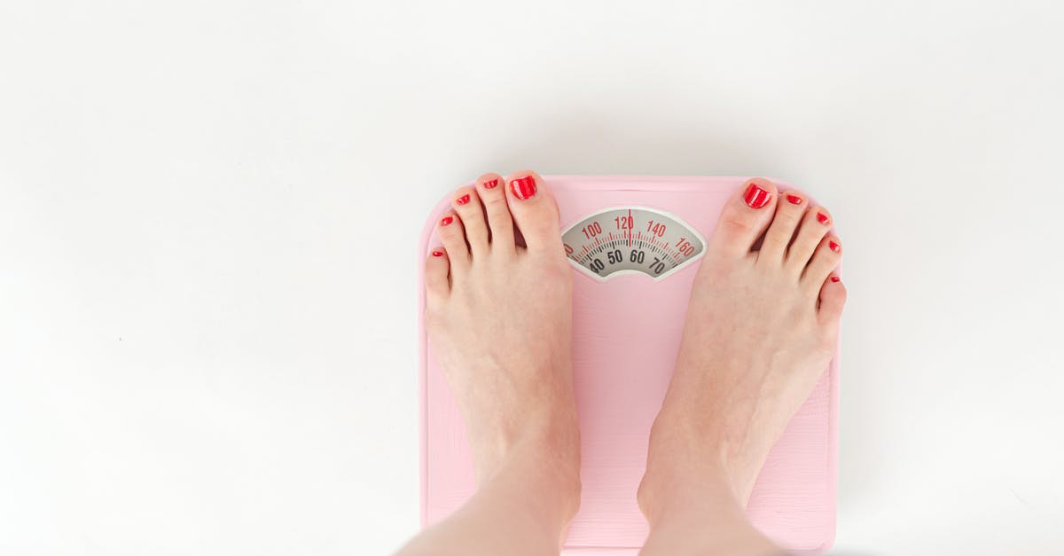 Do airlines sometimes check the weight of the passengers' clothes? [closed] - Top view of crop anonymous barefoot female measuring weight on scales on white background