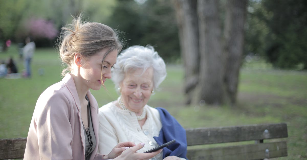 Do all GPS devices support all major regions? - Side view of smiling adult female helping aged mom in using of mobile phone while sitting together in park Do all GPS devices support all major regions? - Side view of smiling adult female helping aged mom in using of mobile phone while sitting together in park