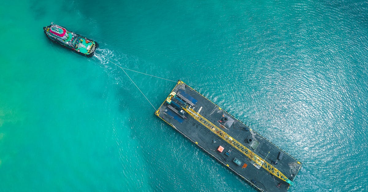 Do cruise passengers answer In Transit on the ESTA application? - Aerial view of modern vessel floating on rippling blue seawater and pulling big platform Do cruise passengers answer In Transit on the ESTA application? - Aerial view of modern vessel floating on rippling blue seawater and pulling big platform