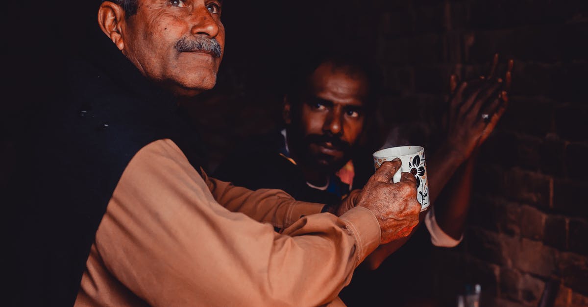 Do I need a transit visa with an Indian passport? - Old Indian man with gray hair and mustache sitting with cup of hot drink in brick poor building Do I need a transit visa with an Indian passport? - Old Indian man with gray hair and mustache sitting with cup of hot drink in brick poor building