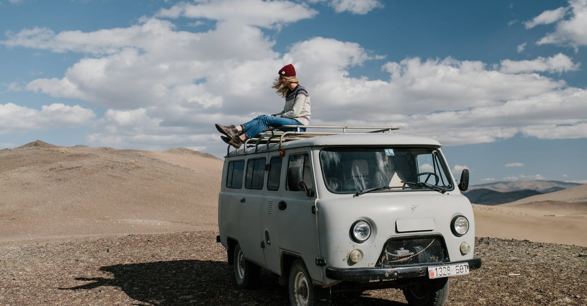 Do I need a vehicle rental to explore Miami FL? - Full length of anonymous female traveler sitting on roof of van in desert under cloudy sky Do I need a vehicle rental to explore Miami FL? - Full length of anonymous female traveler sitting on roof of van in desert under cloudy sky