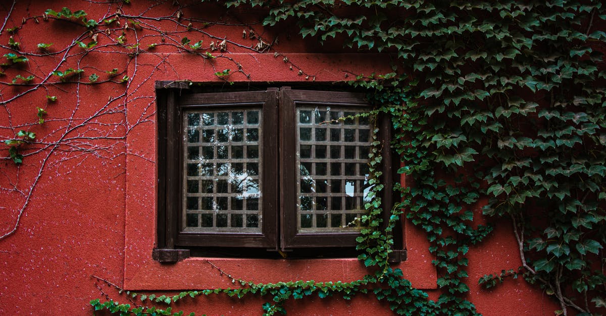 Do I need my old passport for Canadian permanent residence application? [closed] - Exterior of aged wall of red house with closed wooden window and green plants