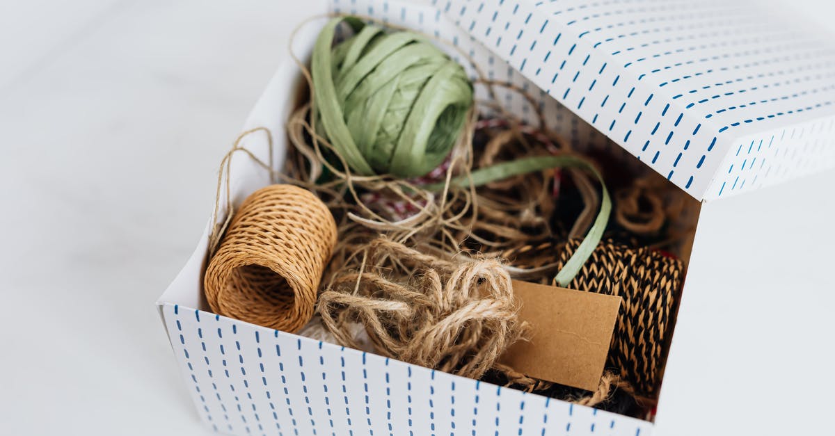 Do I need my physical NEXUS card to receive benefits at the airport? [closed] - From above open carton box filled with various ribbons and ropes for holiday presents and gifts wrapping and blank brown cardboard card placed on white table