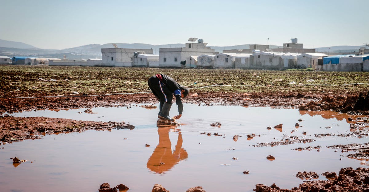 Do I need to clear immigration for a layover in IST? - Full body of anonymous male pouring dirty water on legs in pond surrounded with settlement of refugee Do I need to clear immigration for a layover in IST? - Full body of anonymous male pouring dirty water on legs in pond surrounded with settlement of refugee