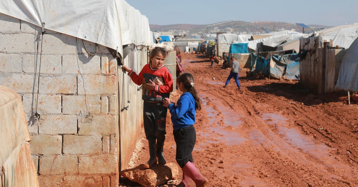 Do I need to clear immigration for a layover in IST? - Full body of preschool and teenage ethnic girls speaking near weathered old brick residential building in poor settlement Do I need to clear immigration for a layover in IST? - Full body of preschool and teenage ethnic girls speaking near weathered old brick residential building in poor settlement