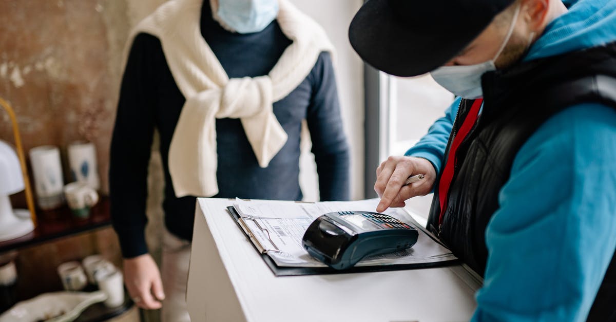 Do I need to pay the package transmission fee (Canadian visa)? - Delivery Man Using a Payment Terminal Do I need to pay the package transmission fee (Canadian visa)? - Delivery Man Using a Payment Terminal
