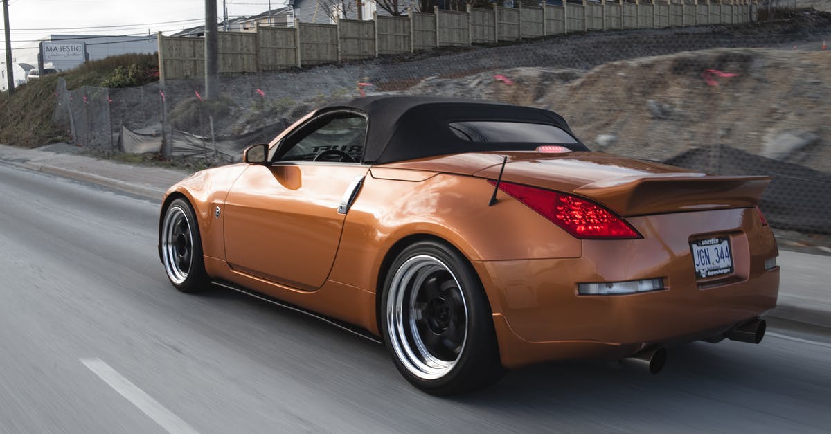 Do I need to pre-register my foreign car to drive in Milan's Zone B? - Modern luxury light brown auto with shiny surface driving on asphalt roadway near fence and rural buildings under sky in daylight