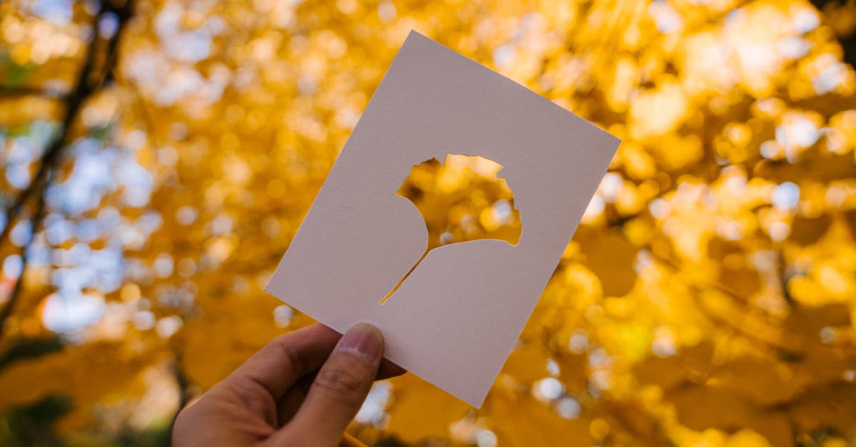 Do I need to show my passport when I leave the UK? - Person showing card against yellow autumn leaves Do I need to show my passport when I leave the UK? - Person showing card against yellow autumn leaves