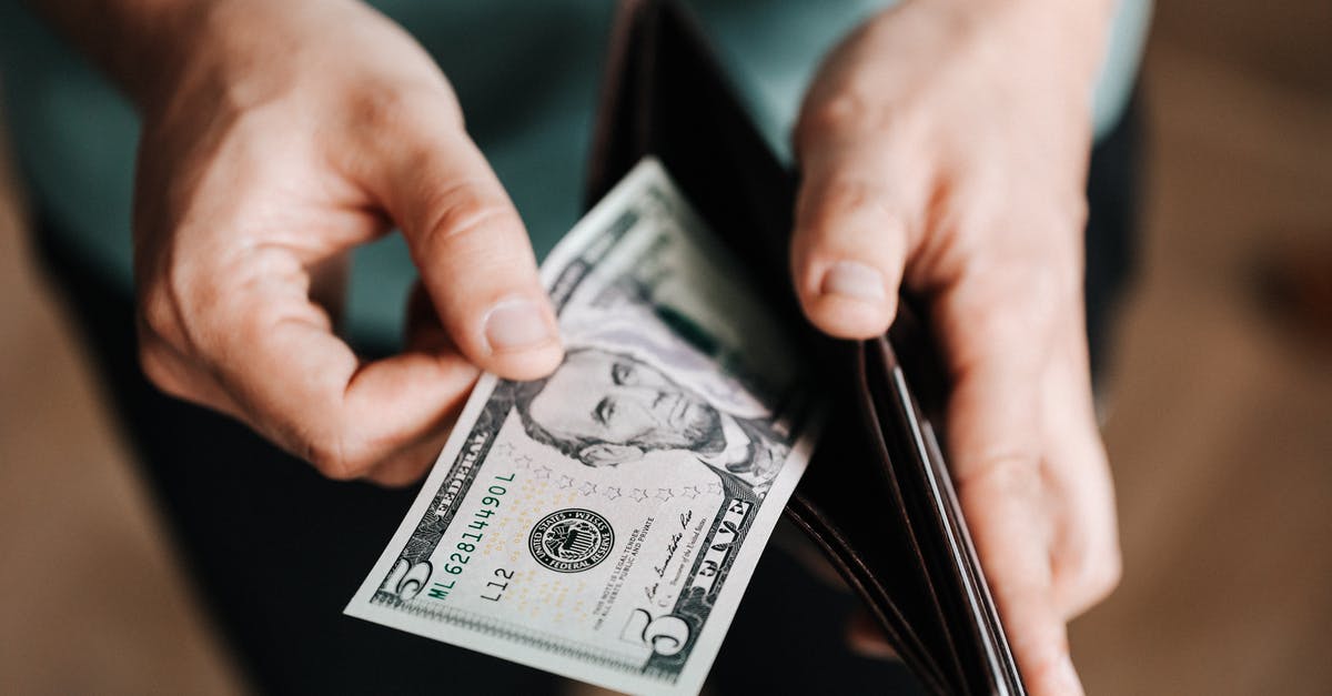 Do I need to take cash on my holiday to Sardinia? - Unrecognizable man holding wallet with money