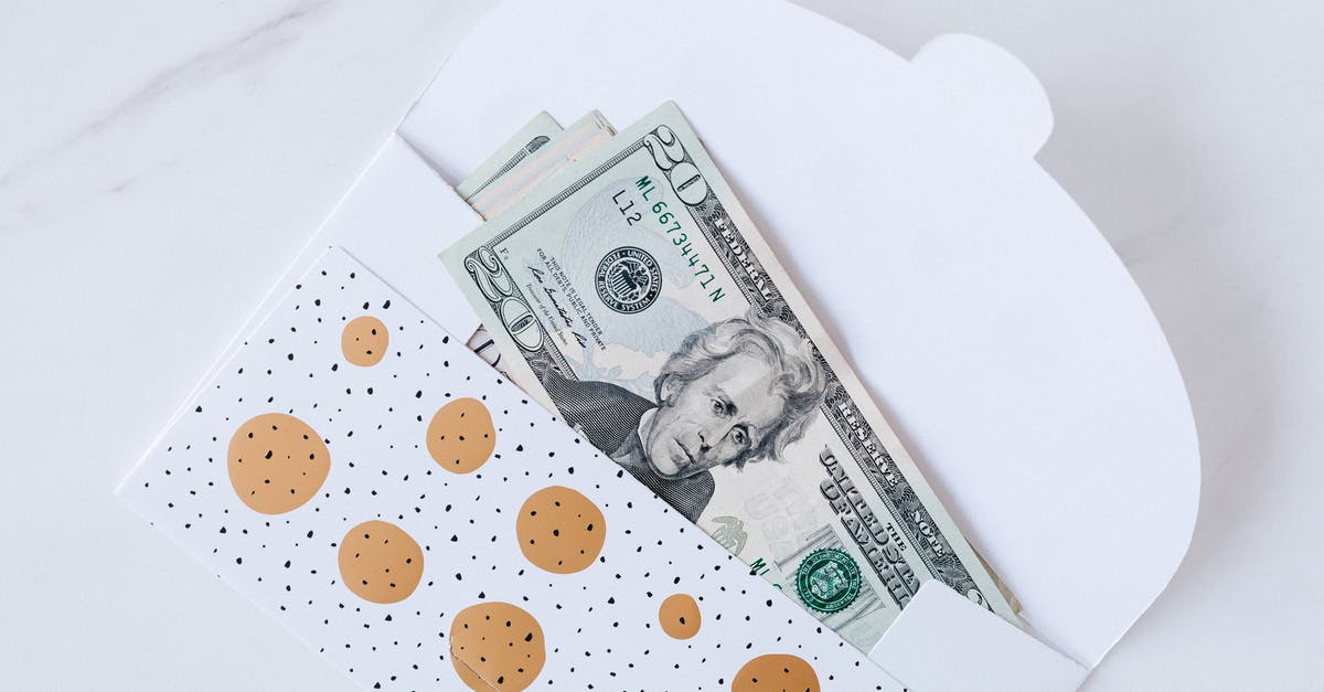 Do I need to take cash on my holiday to Sardinia? - Money envelope with American dollar banknotes on white surface