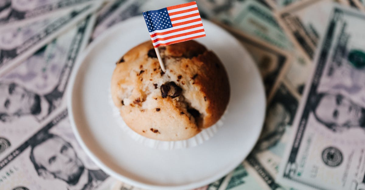 Do I need to take cash on my holiday to Sardinia? - Tasty cake with flag on bunch of paper dollars