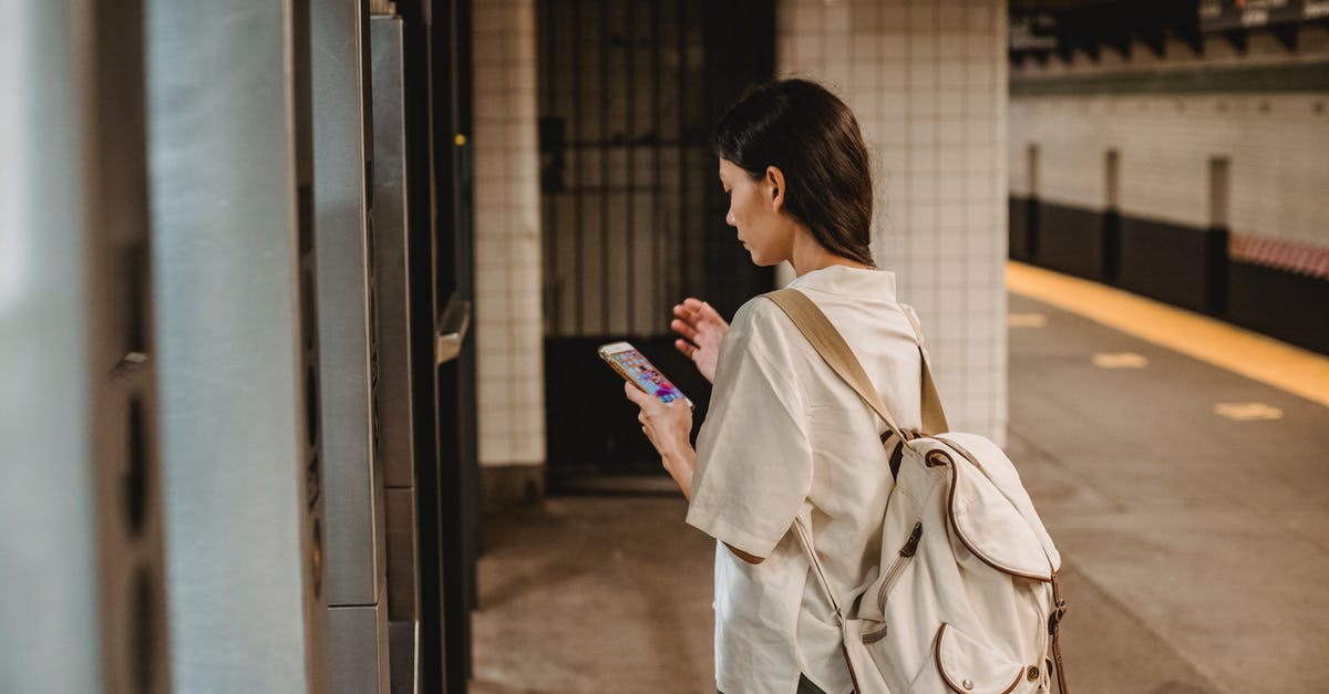 Do I need to validate train tickets that were purchased online? - Side view of young concentrated ethnic female in casual clothes and backpack browsing mobile phone while standing on platform of subway station Do I need to validate train tickets that were purchased online? - Side view of young concentrated ethnic female in casual clothes and backpack browsing mobile phone while standing on platform of subway station