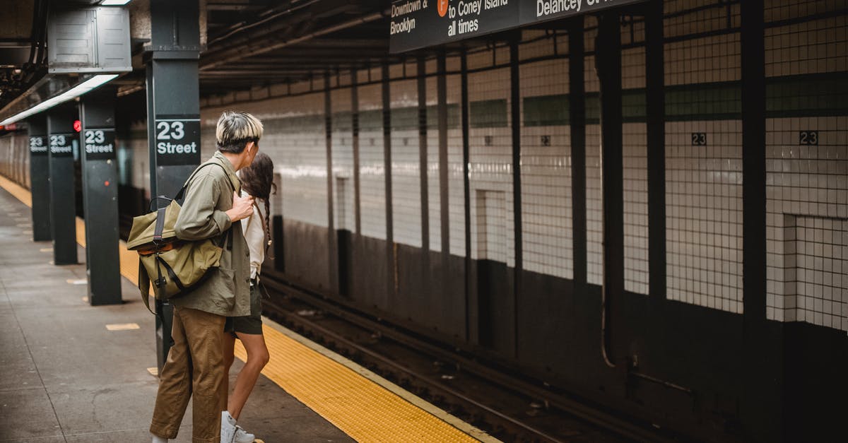 Do I need UK transit visa to move from Terminal 2 to Terminal 3 Heathrow? [duplicate] - Side view of unrecognizable young man and woman in trendy outfits and backpack looking away while waiting for train in underground station