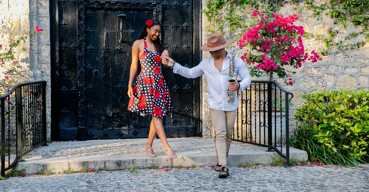 Do I qualify to travel UK > Cuba via Miami as a non US citizen under the ‘family member’ general licence category? - Man and Woman Standing on Gray Concrete Floor