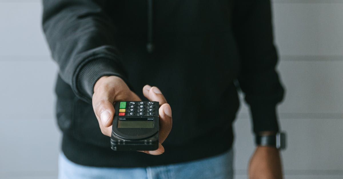 Do North American banks have a key phrase that allows customers to disable all security checks for using the card internationally? - Person in Black Long Sleeve Shirt Holding Black Smartphone