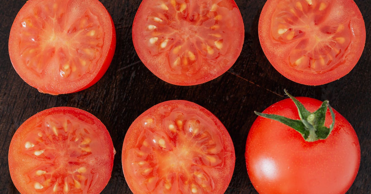 Do seasonal flights from Trondheim to Edinburgh, London, or any other part of the UK exist? - Top view closeup of fresh halves of ripe tomatoes with juice on cut side and whole tomato placed on wooden cutting board