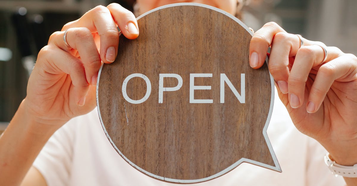Do shops in Germany open on 2nd Jan? - Happy woman showing wooden signboard saying open Do shops in Germany open on 2nd Jan? - Happy woman showing wooden signboard saying open