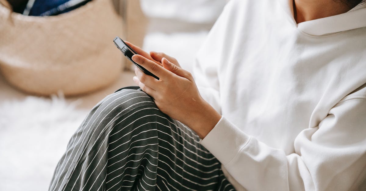 Do skincare sheet masks fall in the liquids category for carry ons? - From above of unrecognizable female in sheet mask surfing cellphone while sitting on floor with bent leg in light room on blurred background