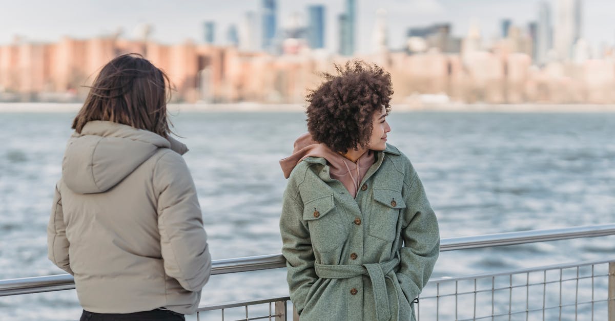 Do the governments of United Kingdom and USA share immigration data? - Young female friends wearing warm clothes standing together with hands in pockets on New York City promenade on cold day Do the governments of United Kingdom and USA share immigration data? - Young female friends wearing warm clothes standing together with hands in pockets on New York City promenade on cold day