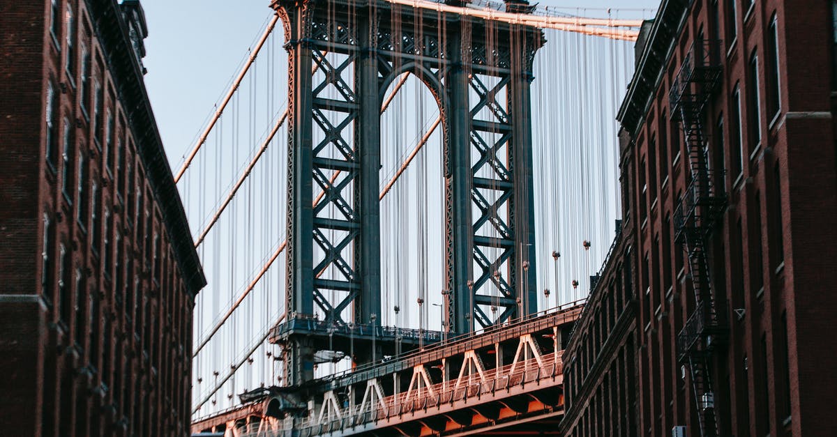 Do the road rules change from DC to NY in USA? - From below of bridge with metal heavy arch near concrete buildings under cloudless blue sky Do the road rules change from DC to NY in USA? - From below of bridge with metal heavy arch near concrete buildings under cloudless blue sky
