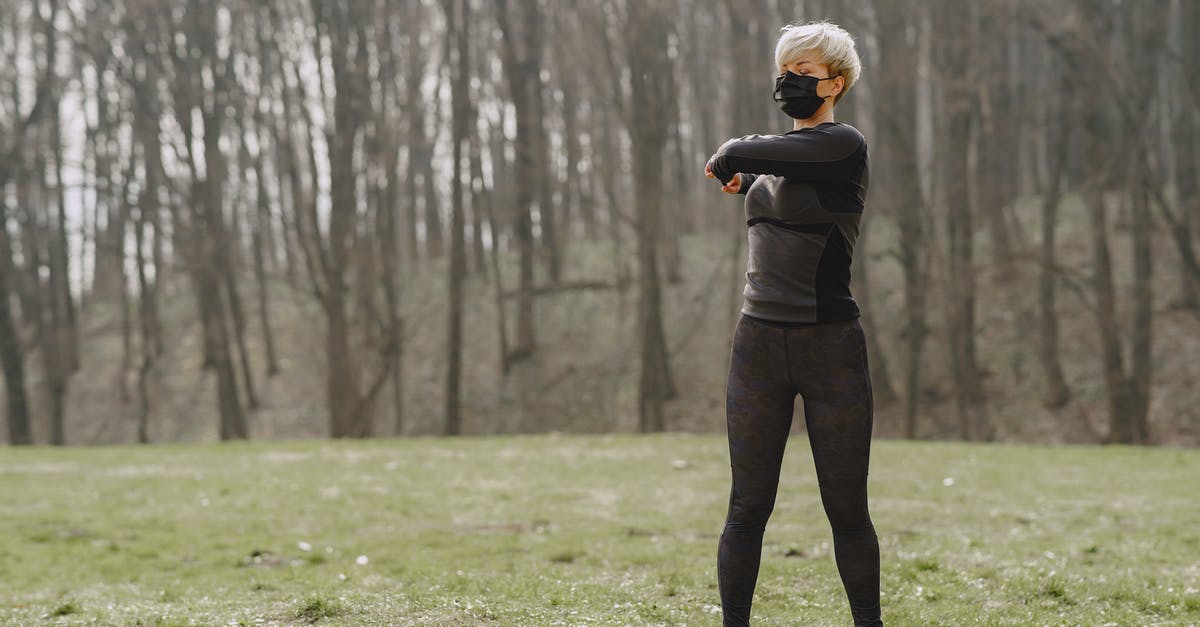 Do vouchers offered by EU airlines for Coronavirus cancellations turn into a full refund if not used? - Full length young female in sportswear and mask making turns and kneading upper back while standing on green meadow in park
