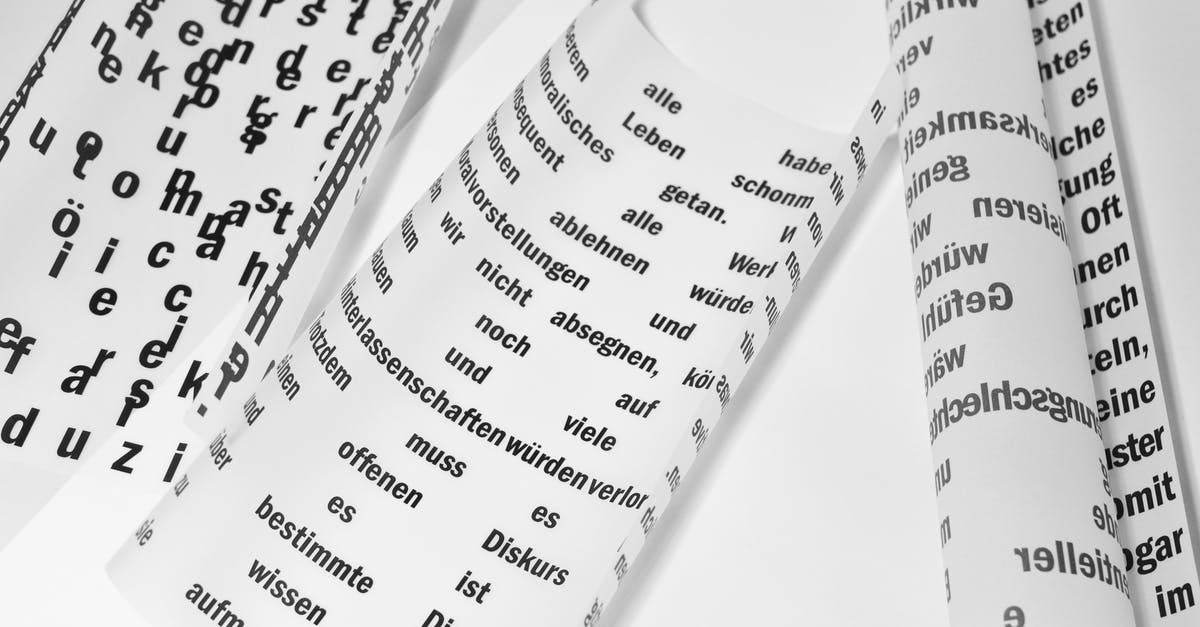 Document stamping - From above of rolled sheets of paper with inscriptions written in German language placed on white background in light room