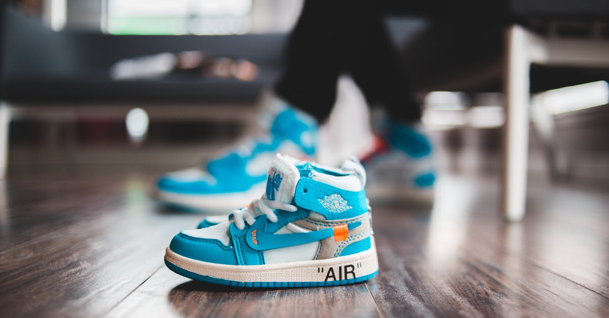 Documentation requirements for a baby for domestic air travel within India - Tiny vibrant sneakers for baby on wooden floor in bright room in daylight on blurred background Documentation requirements for a baby for domestic air travel within India - Tiny vibrant sneakers for baby on wooden floor in bright room in daylight on blurred background