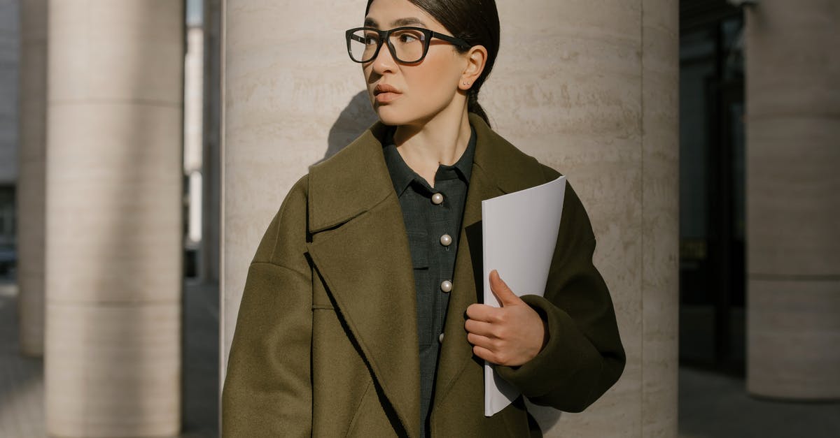 Documents required for B2 at airport - Woman in Brown Coat Holding White Paper Documents required for B2 at airport - Woman in Brown Coat Holding White Paper