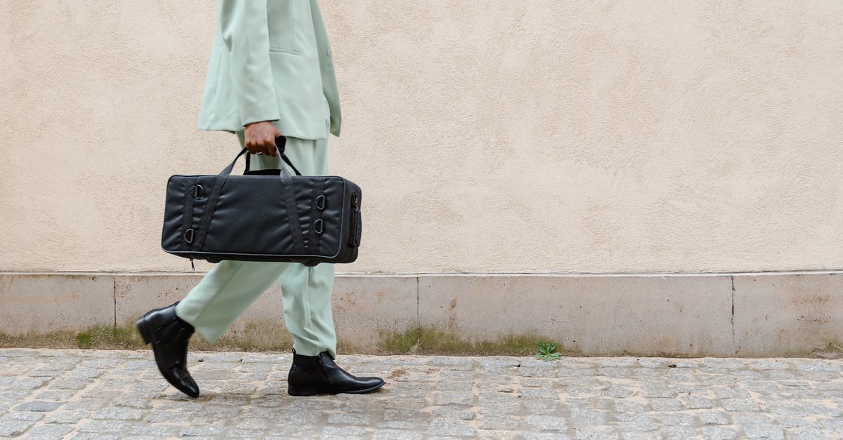 Does a suit fit in a carry-on bag or rollaboard? - Person Walking in the Street Carrying a Black Bag Does a suit fit in a carry-on bag or rollaboard? - Person Walking in the Street Carrying a Black Bag