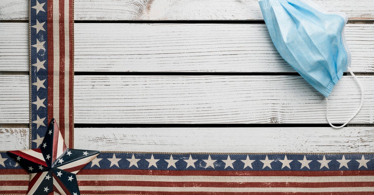 Does a US national need a medical visa to receive treatment in Australia? - Top view of ribbons and star badge with US flag pattern decorating rustic white wooden table with medical mask