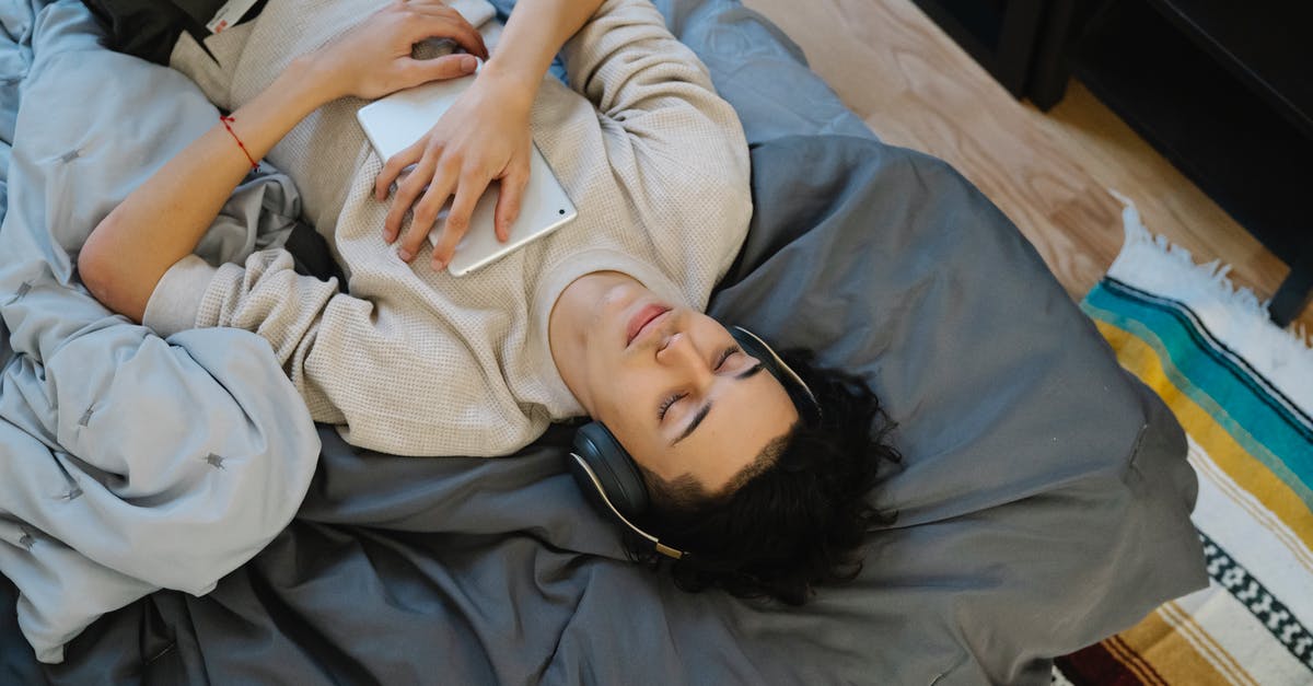 Does draft evasion sound like a valid reason for applying for a US visa outside your home country? [closed] - From above young Hispanic guy with tablet listening to music with closed eyes while chilling on comfortable bed at home