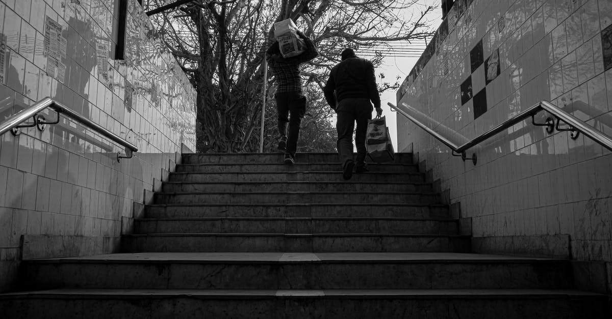 Does Eurowings weigh carry-on bags? - Grayscale Photo of Man Walking on Stairs