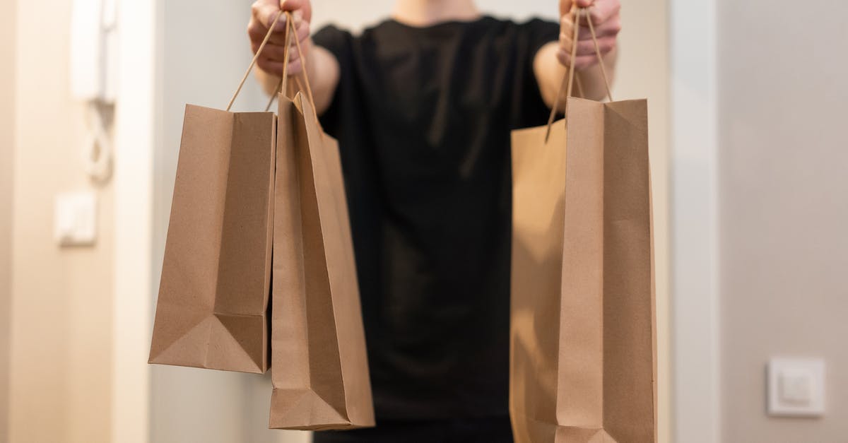 Does Eurowings weigh carry-on bags? - Man in Black Crew Neck Shirt Holding Brown Paper Bag