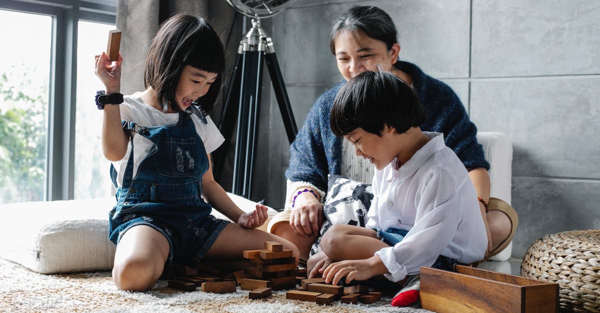 Does Indigo have manual check-in to get boarding pass? - Cheerful little Asian siblings sitting on carpet with grandmother and playing tower game during weekend at home Does Indigo have manual check-in to get boarding pass? - Cheerful little Asian siblings sitting on carpet with grandmother and playing tower game during weekend at home