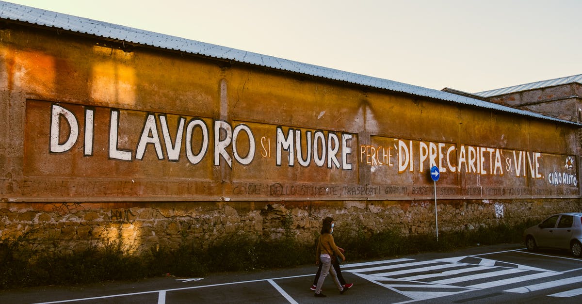 Does Italian citizens need a passport for a stopover in Kyiv, Ukraine? - Anonymous citizens strolling on road against building with inscription Does Italian citizens need a passport for a stopover in Kyiv, Ukraine? - Anonymous citizens strolling on road against building with inscription