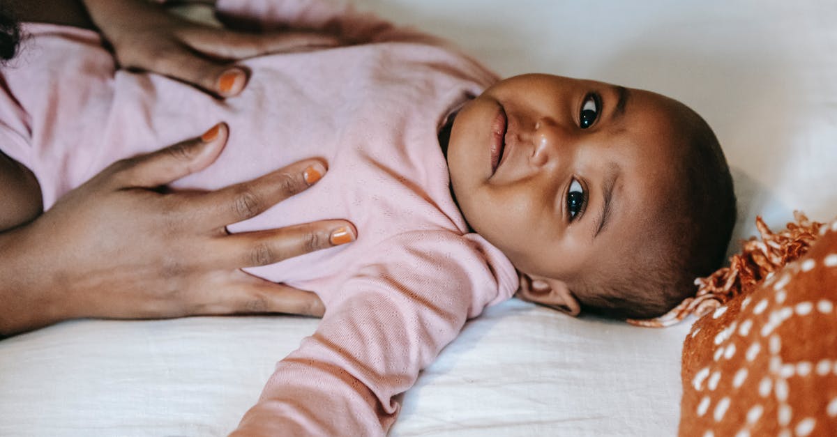 Does my daughter need consent from both parents? - Black mother stroking baby lying on bed Does my daughter need consent from both parents? - Black mother stroking baby lying on bed