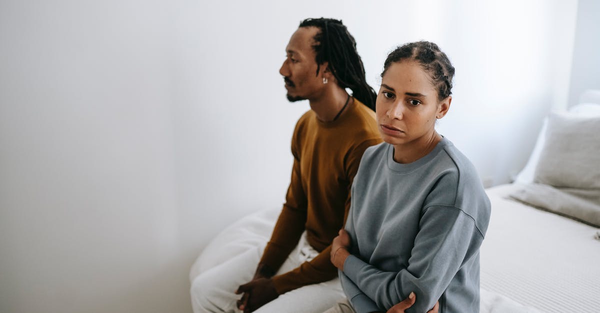 Does my wife, who is accompanying me to a conference in Australia, need a separate visa application? - Unhappy black couple sitting on bed together Does my wife, who is accompanying me to a conference in Australia, need a separate visa application? - Unhappy black couple sitting on bed together