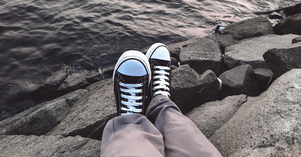 Does United's Harvey travel waiver apply to flights that have some legs or all legs operated by partner airlines? - A Person Wearing Sneakers on a Rocky Coast